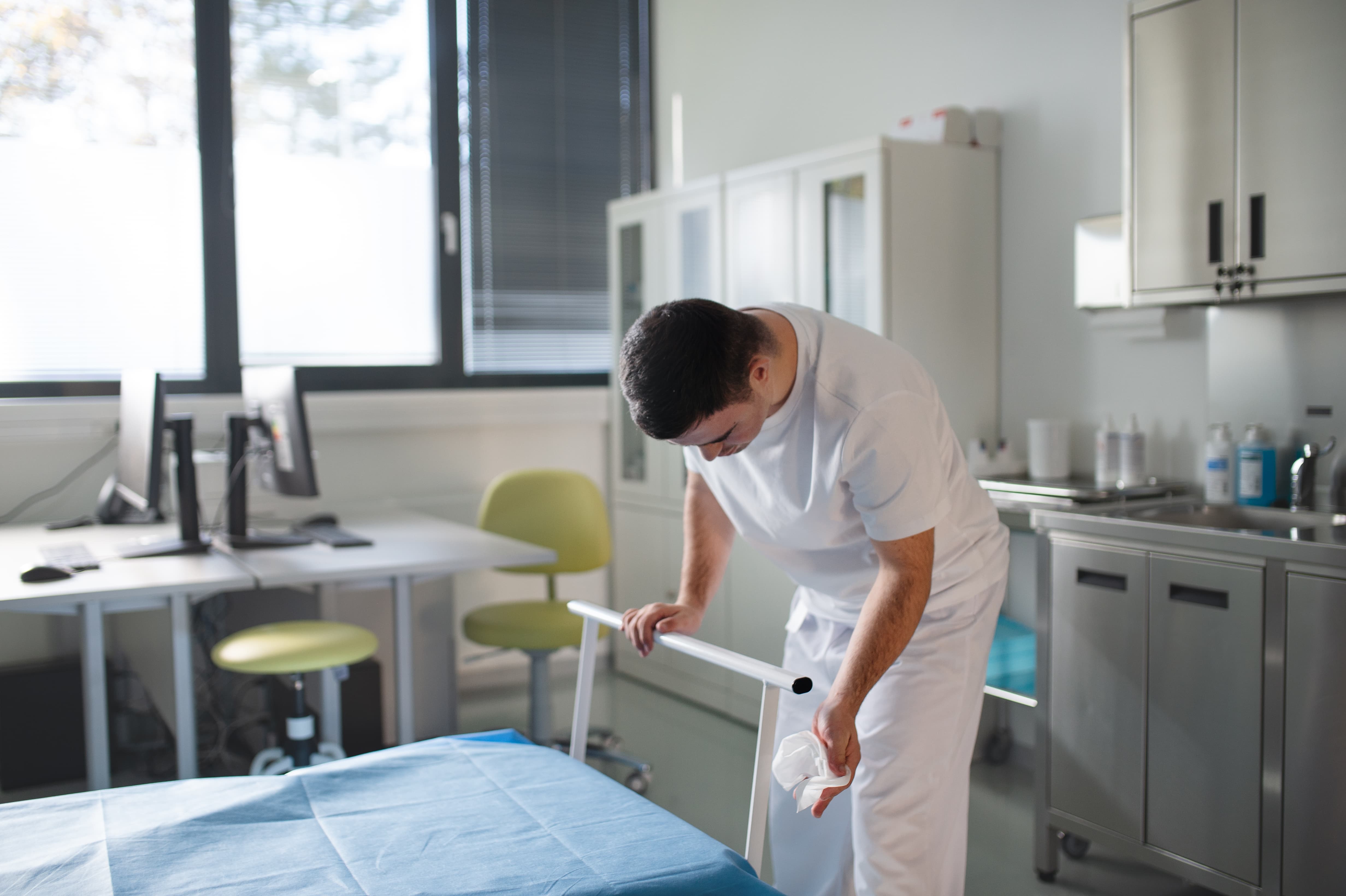 Professionelle Praxis- und Klinikreinigung in Hamburg: Eine Fachkraft reinigt hygienisch und zuverlässig eine Untersuchungsliege. Polarglanz sorgt für keimfreie Praxisräume, Wartezimmer, Eingangsbereiche und Büroräume durch tägliche Reinigung und Desinfektion.